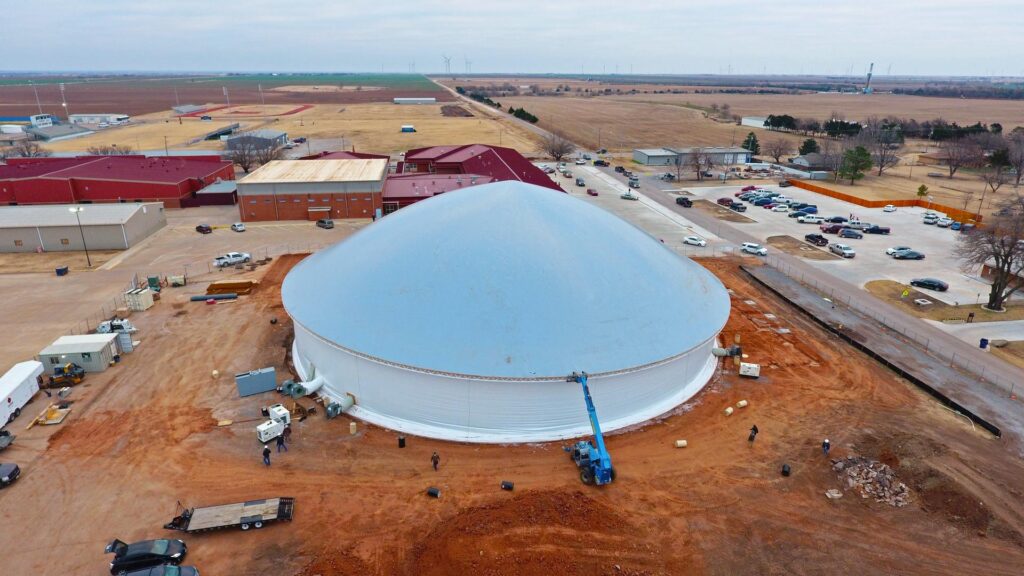 Fully inflated stem wall dome, with telehandler stabilizing transition ring. The Hennessy Eagles Event Center in Oklahoma provides an excellent space for activities and shelter.